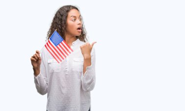 Estates işaret ve başparmak kadar mutlu yüz gülümseyen tarafı ile gösterilen Amerika bayrağı tutan genç İspanyol kadın