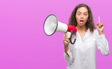 Megafon sürpriz bir fikir ya da soru işaret parmağı ile gülen yüz, bir numara tutan genç İspanyol kadın