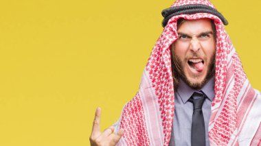 Genç yakışıklı Arap adam uzun saçlı rock simge elle yapıyor deli ifade ile bağırarak izole arka plan üzerinde keffiyeh giyiyor. Müzik yıldızı. Ağır kavramı.