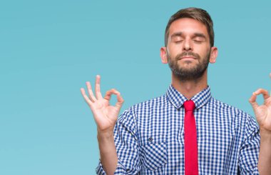 Genç yakışıklı iş adamı izole arka plan üzerinde dinlenmek ve gülümseyen gözlerle kapalı parmak jestle meditasyon yapıyor. Yoga kavramı.