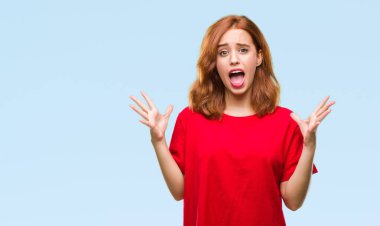 Genç güzel kadın deli kutluyor ve silah ile başarı için heyecanlı çığlık kaldırdı ve açık gözleri hayret izole arka plan yüzünden. Kazanan kavramı