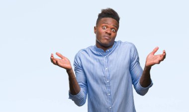 Genç Afro-Amerikalı iş adamı izole arka plan clueless ve şaşkın bir ifadeyle kollar ve eller kaldırdı üzerinde. Şüphe kavramı.