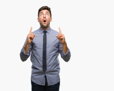 Genç yakışıklı iş adamı izole arka plan üzerinden hayran ve yukarıya bakıp parmakları ile işaret şaşırttı ve silah kaldırdı.