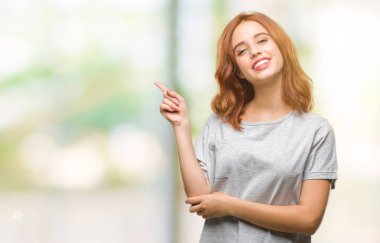 Kameraya bakarak yan el ve parmak ile işaret izole arka yüzünde kocaman bir gülümseme ile genç güzel kadın.