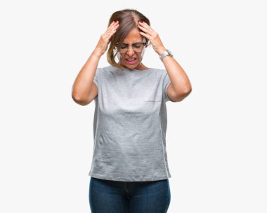 Çünkü çaresiz ve stresli baş ağrısı acı izole arka plan üzerinde gözlük takan orta yaş İspanyol kadın kıdemli ağrı ve migren. Ellerini kafasına.