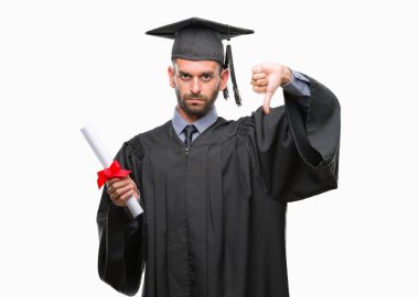 Genç yakışıklı derece kızgın yüzü, eksi işareti aşağı antipati başparmak ile gösterilen, ret kavramı ile izole arka plan üzerinde tutan adam mezun oldu.