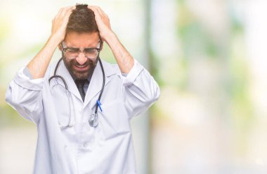 Yetişkin İspanyol doktor adam çünkü umutsuz ve stresli baş ağrısı acı izole arka plan üzerinde ağrı ve migren. Ellerini kafasına.