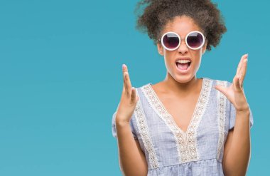 Genç afro Amerikalı kadın üzerinde gözlük takan arka plan deli izole ve deli bağırarak ve agresif ifade ve silah kaldırdı bağırıyor. Hayal kırıklığı kavramı.