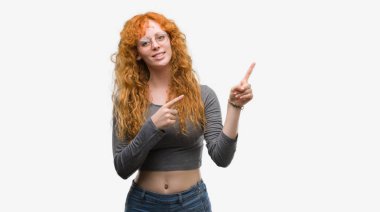 Gülümseyen ve iki ile işaret kamera bakarak genç Kızıl saçlı kadın eller ve yan parmak.