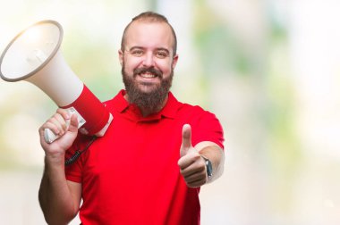 Beyaz delikanlı ok işareti, başparmak ile parmak, mükemmel işareti yapıyor kocaman bir gülümseme ile izole arka plan üzerinde mutlu megafon ile bağırarak