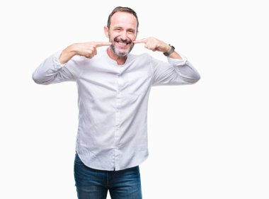 Orta yaş emin gösterilen ve işaret parmakları diş ve ağız ile gülümseyen izole arka plan üzerinde ağarmış komuta sizde. Sağlık kavramı.
