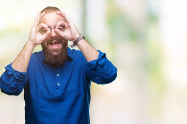 Dilini, parmaklarının arasından baktığını yapışmasını dürbün gibi ok jest yapıyor izole arka plan üzerinde gözlük takan Genç beyaz hipster adam. Deli ifade.