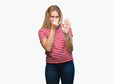 Bir şey pis ve iğrenç kokulu izole arka plan, dayanılmaz koku, holding nefes burun parmaklar ile genç beyaz kadın. Kötü kokuyor kavramı.