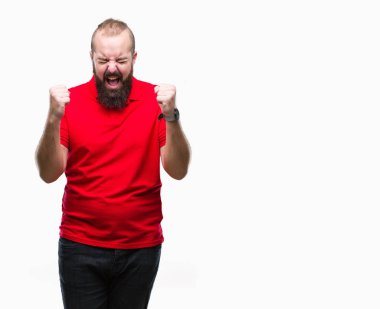 İzole arka kolları olan başarı için heyecan üzerinde kırmızı gömlek giymiş genç beyaz hipster adam zafer kutluyor gülümseyen kaldırdı. Kazanan kavramı.