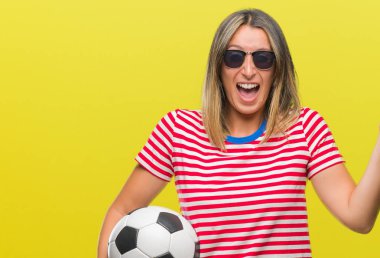 Futbol futbol topu tutan genç güzel kadın büyük gülümseme ile çığlık zaferini kutluyor ve ellerini kaldırdı arka plan çok mutlu ve heyecanlı, kazanan ifade izole