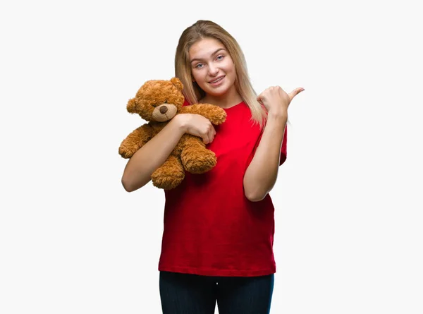 Jovem Caucasiano Mulher Segurando Bonito Ursinho Sobre Isolado Fundo Apontando — Fotografia de Stock