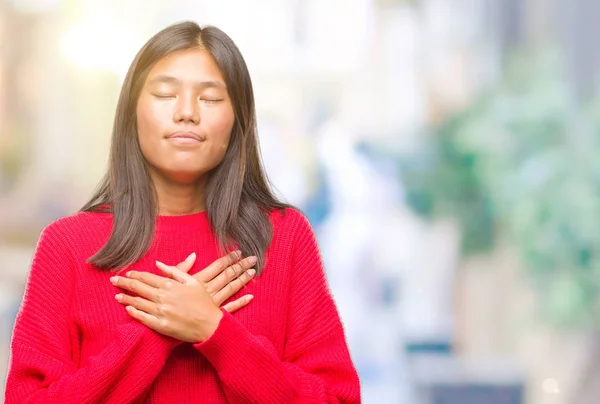 年轻的亚洲妇女穿着冬季毛衣在孤立的背景微笑着双手在胸前闭上眼睛和感激的手势脸上 健康理念 — 图库照片