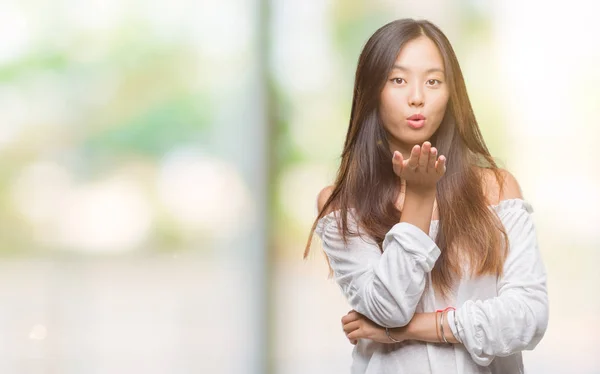 Молодая Азиатская Женщина Изолированном Фоне Смотрящая Камеру Дующая Поцелуй Рукой — стоковое фото