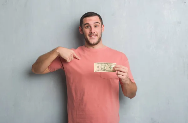 Young Caucasian Man Grey Grunge Wall Showing Ten Dollars Surprise — Stock Photo, Image