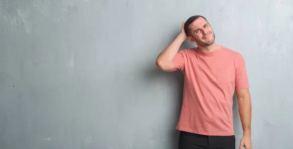 Joven Caucásico Hombre Sobre Gris Grunge Pared Confundir Preguntarse Acerca —  Fotos de Stock