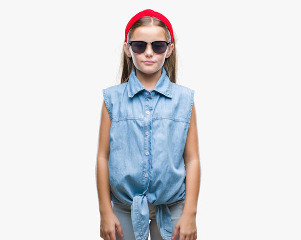Young beautiful girl wearing sunglasses over isolated background with serious expression on face. Simple and natural looking at the camera.