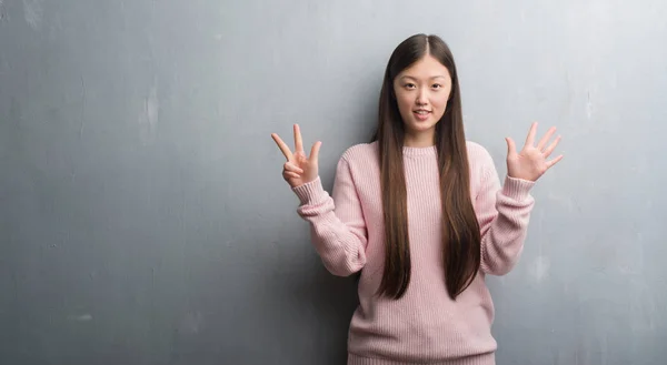 Jonge Chinese Vrouw Grijs Muur Tonen Met Vingers Omhoog Nummer — Stockfoto