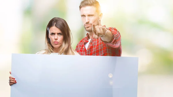 Casal Jovem Juntos Segurando Banner Branco Sobre Fundo Isolado Apontando — Fotografia de Stock