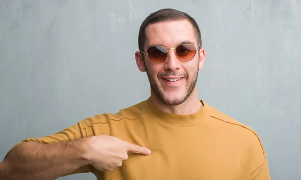 Young Caucasian Man Grey Grunge Wall Wearing Sunglasses Surprise Face — Stock Photo, Image