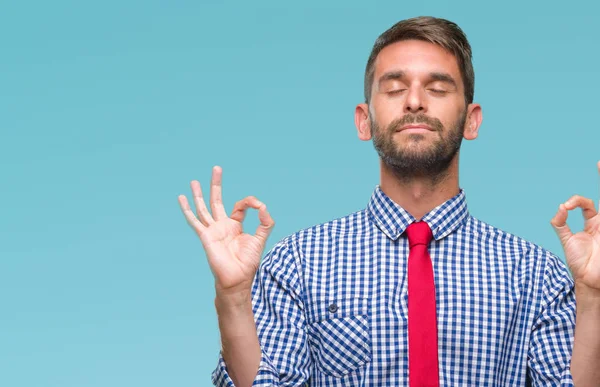 Genç yakışıklı iş adamı izole arka plan üzerinde dinlenmek ve gülümseyen gözlerle kapalı parmak jestle meditasyon yapıyor. Yoga kavramı.