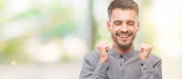 流行に敏感な若い男の腕の成功のために興奮して祝う勝利笑顔に発生します 勝者の概念 — ストック写真