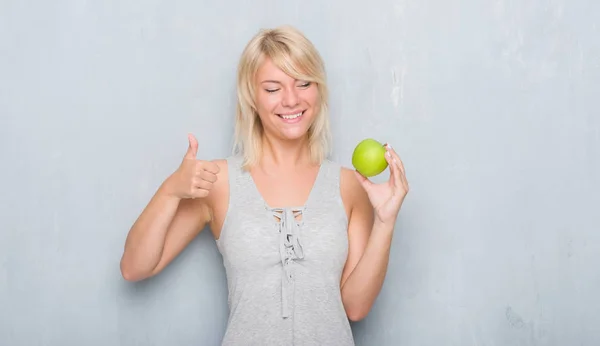 Mujer Caucásica Adulta Sobre Pared Gris Grunge Comiendo Manzana Verde — Foto de Stock