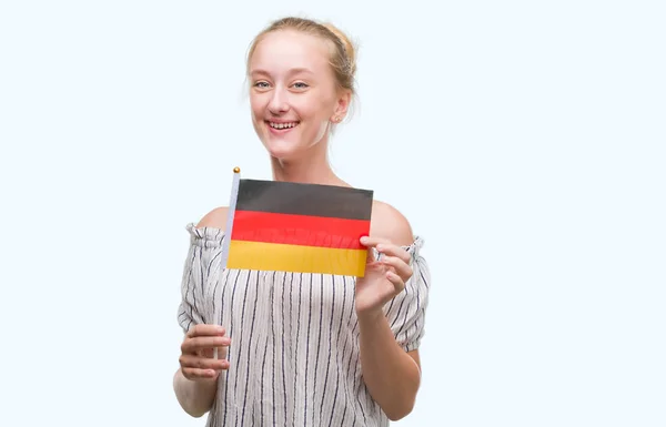 立っていると自信を持って歯を見せて笑顔で笑っている幸せそうな顔でドイツの国旗を保持している金髪 代女性 — ストック写真