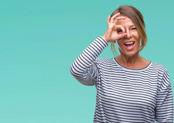 Orta yaş üst düzey İspanyol kadın gülümsüyor, parmakları ile mutlu yüz üzerinden seyir göz el ile ok jest yapıyor izole arka plan.