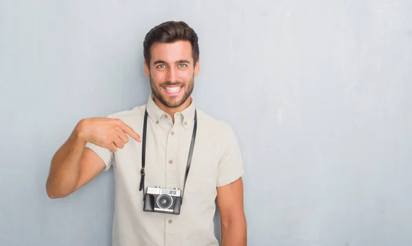 Guapo Joven Sobre Gris Grunge Pared Sosteniendo Cámara Fotos Vintage — Foto de Stock