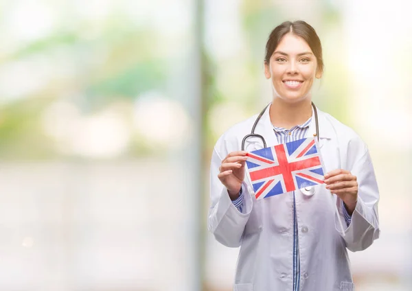 Jovem Médica Hispânica Segurando Bandeira Reino Unido Com Rosto Feliz — Fotografia de Stock