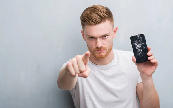 Νέοι Κοκκινομάλλα Άνδρα Πάνω Τοίχο Γκρι Grunge Κρατώντας Σπασμένα Smartphone — Φωτογραφία Αρχείου