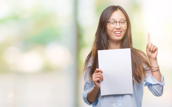 Jovem Mulher Asiática Segurando Papel Branco Sobre Fundo Isolado Surpreso — Fotografia de Stock