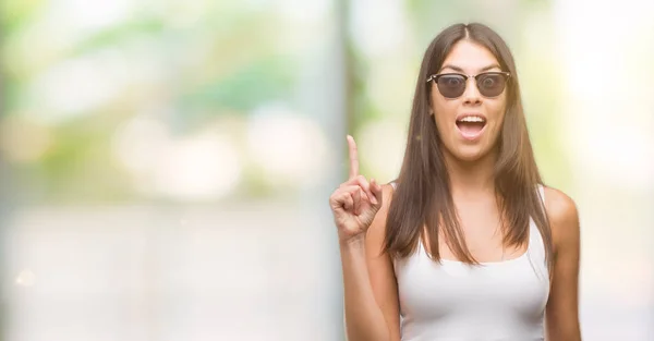 Giovane Bella Ispanico Indossare Occhiali Sole Puntando Dito Verso Alto — Foto Stock