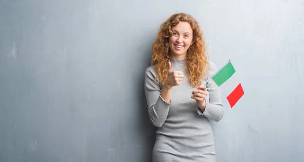 Молодих Redhead Жінка Над Сірий Гранж Настінні Холдинг Прапор Італії — стокове фото