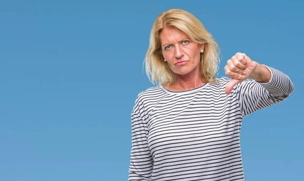 Middle age blonde woman over isolated background looking unhappy and angry showing rejection and negative with thumbs down gesture. Bad expression.