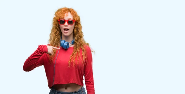 Mujer Pelirroja Joven Con Auriculares Con Cara Sorpresa Señalando Dedo —  Fotos de Stock