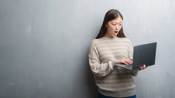Junge Chinesin Über Graue Wand Mit Computer Laptop Erschrocken Mit — Stockfoto