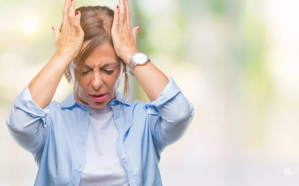 中年资深西班牙裔妇女在孤立的背景下患有头痛绝望和压力 因为疼痛和偏头痛 手在头上 — 图库照片