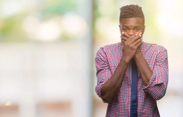 Genç Afro-Amerikalı iş adamı izole arka plan ağız hata için elleriyle kapsayan şok içinde. Gizli kavramı.