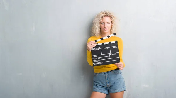 Junge Blonde Frau Über Grunge Grauer Wand Mit Einem Selbstbewussten — Stockfoto