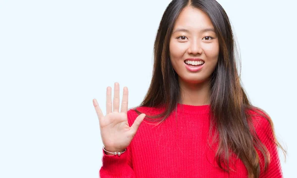 孤立した背景表示と指で上向きに若いアジア女性着て冬セーター数は自信を持って 幸せな笑みを浮かべている間 — ストック写真