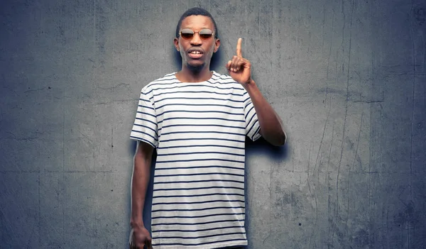 Afrika siyah adam mutlu ve yukarı dönük ifade wow jest tezahürat güneş gözlüğü takıyor