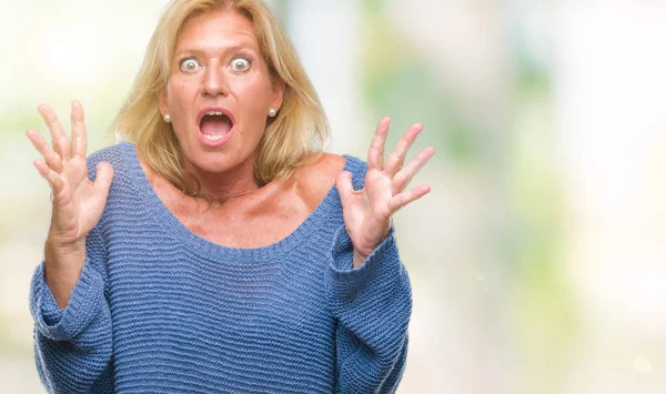 Orta yaş sarışın kadın üzerinde kış kazak giyen arka plan deli izole ve deli bağırarak ve agresif ifade ve silah kaldırdı bağırıyor. Hayal kırıklığı kavramı.