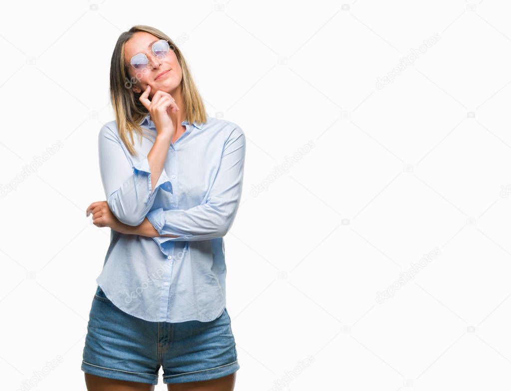 Young beautiful woman wearing sunglasses over isolated background with hand on chin thinking about question, pensive expression. Smiling with thoughtful face. Doubt concept.