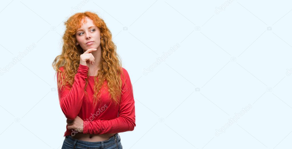 Young redhead woman serious face thinking about question, very confused idea